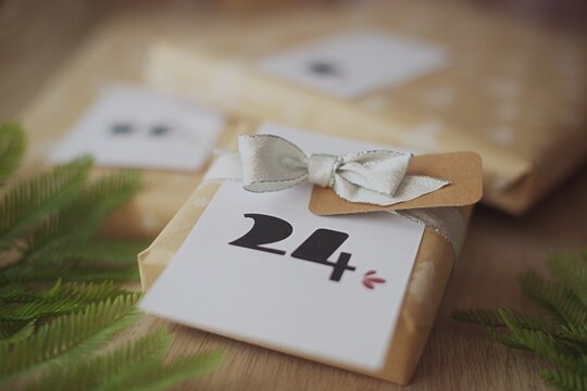 Close-up of a stack of Gift boxes for a homemade Christmas advent calendar with ribbon on a wooden table