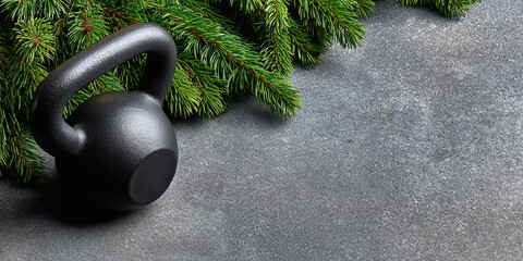 Kettlebell fitness holiday evergreen pine branch concrete background strength training calm fitness holiday scene with evergreen pine branch concrete background, black kettlebell for strength