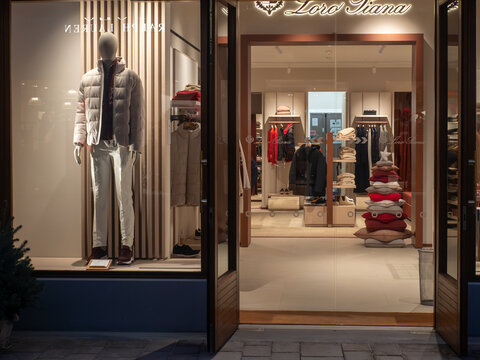 Fidenza Village luxury outlet store window featuring Loro Piana and Ralph Lauren fashion during Christmas shopping season
