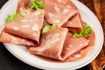 Mortadella sausage slices meat food tasty snack fresh delicious gourmet food background on the table rustic food top view copy space