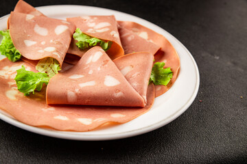 Mortadella sausage slices meat food tasty snack fresh delicious gourmet food background on the table rustic food top view copy space