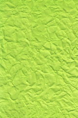 Bright green crumpled paper texture background with visible folds and wrinkles. Ideal for eco themes, Close-up of green crumpled paper texture, and modern graphic or abstract layouts.