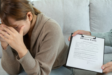 Obraz premium Divorce. husband pass on Divorce form for Wife . Couples desperate and disappointed after marriage. wife sad, upset and frustrated after quarrels conflict. distrust, love problems