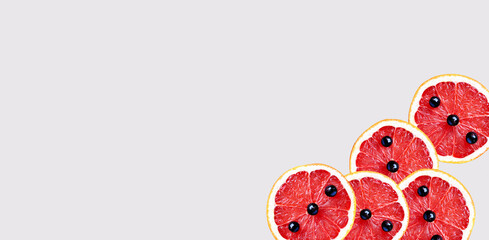 Sliced ​​grapefruit wallpaper. Grapefruit with blackcurrant berries. Citrus slices, isolated, artistic modern art, abstract food backgrounds, healthy eating concepts