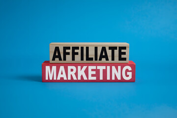 Minimalist affiliate marketing blocks on vibrant blue background, featuring 'AFFILIATE' in black wood and 'MARKETING' in white on red wood, sharp contrast design.