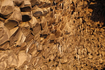 Basalt column formations with ice stalactites at Icelandic Black Sand Beach