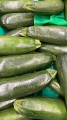 Fresh green zucchini stacked together as organic vegetable background, raw courgette harvest for healthy food concepts