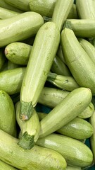 Fresh green zucchini stacked together as organic vegetable background, raw courgette harvest for healthy food concepts