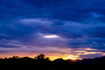 Golden sunset breaking through dramatic clouds symbolizing hope, transition, and inner peace