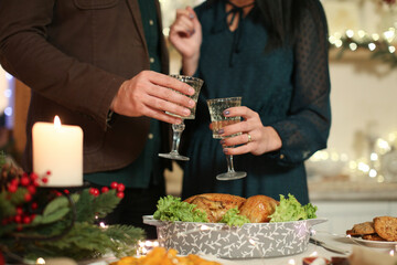 Clinking glasses with champagne during romantic Christmas dinner celebration