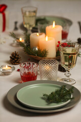 Christmas table with candles, drinks, pine branches and festive decor for holiday celebration