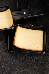 Raclette cheese portion slicing natural product tasty snack fresh delicious gourmet food background on the table rustic top view copy space