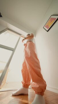 Dancer by window, Expression of movement in home studio setting