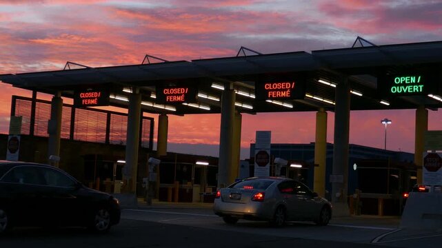 Light traffic at an United States and Canadian international border crossing during a colorful sunset or dawn.