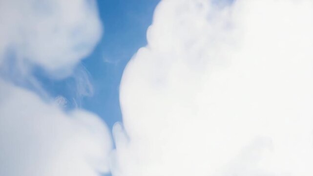 Clouds slowly drift across the blue sky on a bright sunny day in the afternoon