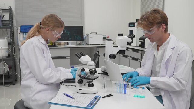 Students work in laboratory with microscopes and computer at a science class