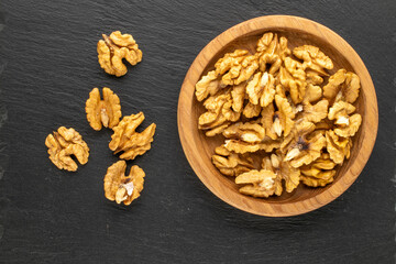 Shelled walnuts on slate stone, macro, top view.