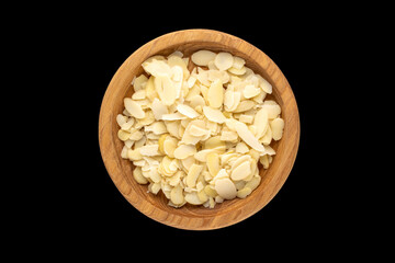 Peanuts cut into slices on a black background, top view.