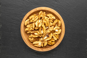 Shelled walnuts on slate stone, macro, top view.