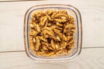 Shelled walnuts on a wooden table, close-up, top view.