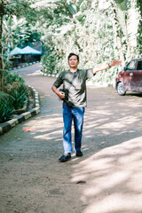 Fototapeta premium Enthusiastic man showing direction in a lush park area
