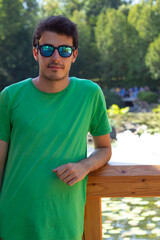 portrait of young handsome man in sunglasses looking at camera