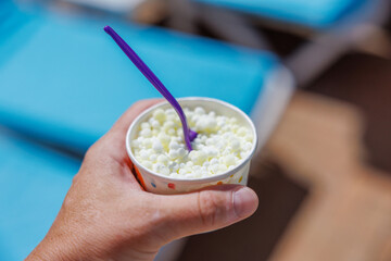 Hand Holding Cup of Dippin' Dots Ice Cream with Purple Spoon © spyrakot