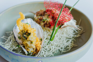 Gourmet seafood presentation with unique fried oyster and creative garnish on a stylish plate