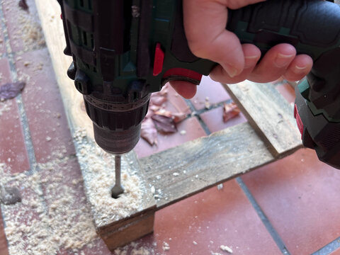 Proceso de perforaci&oacute;n de palets de madera con broca pala para crear una base estructural. Los agujeros permiten insertar tubos de pl&aacute;stico invernadero, mostrando trabajo vista a&eacute;rea 