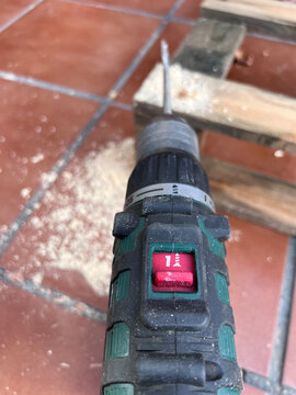 Proceso de perforaci&oacute;n de palets de madera con broca pala para crear una base estructural. Mostrando trabajo vista a&eacute;rea taladro y serr&iacute;n del lado perforado