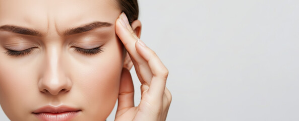 Woman suffering from headache or migraine, eyes closed, temples pressed in pain