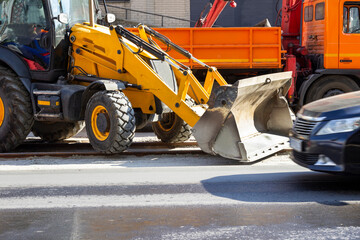 A bulldozer and a dump truck on the road. Repair work.