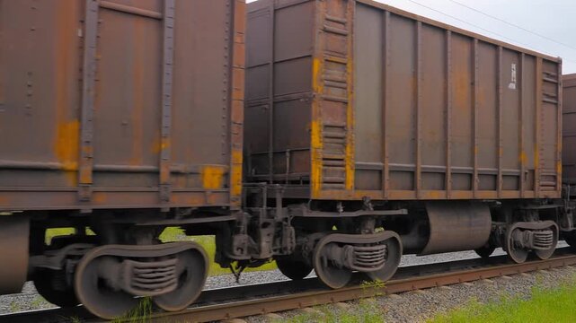 Close-up of a row of freight train cars on a railway track, showcasing industrial transportation and logistics