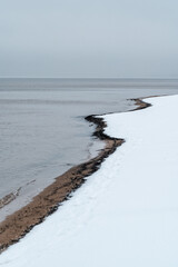Winding shoreline pattern on frozen Baltic Sea beach in winter Latvia
