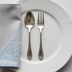 Elegant table setting with classic silverware, white plate, and decorative napkin.
