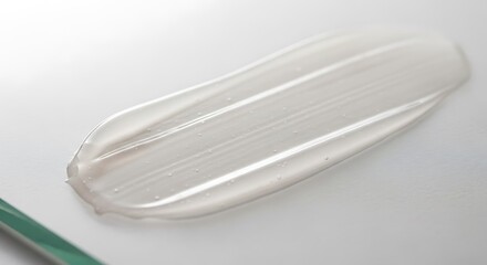 White cosmetic cream or gel smear texture on glass surface
