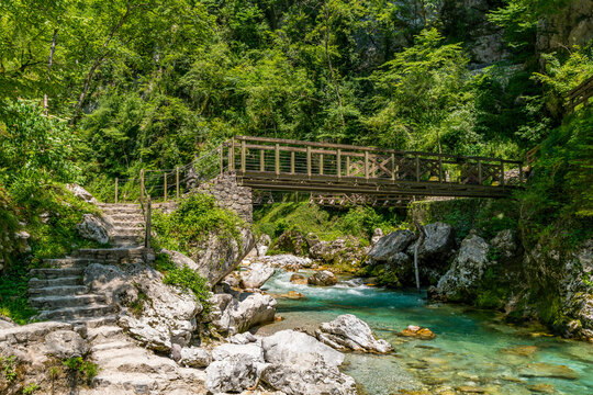 Serene wooden bridge spanning crystal clear waters in Slovenias breathtaking Tolmin Gorges