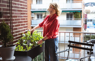 Senior woman gardening with vegetables on home balcony