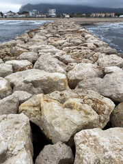 Rocky Mediterranean shoreline with turbulent waves and storm clouds in Oliva Spain
