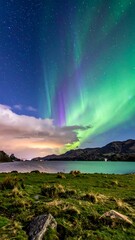 Vibrant aurora borealis paints the night sky above calm lake and landscape
