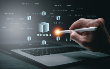A hand interacting with a digital blockchain interface above a laptop, representing blockchain technology, decentralized network, data security, and modern financial innovation.