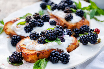 French toasts with cream cheese and fresh blackberries, close-up view. Delicious vegetarian breakfast or dessert