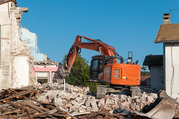 Fototapeta premium Operação de desmantelamento de uma edificação antiga, evidenciando a máquina pesada de lagartas no meio do amontoado de detritos e madeira residuais