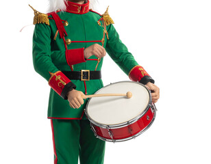 A person in a festive green and red uniform plays a snare drum with a wooden stick