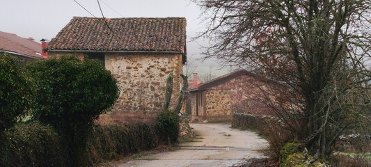 Casas tradicionales de piedra en un pequeño pueblo rural envuelto por la bruma matinal en Verdeña, Palencia, España © Gabrieuskal