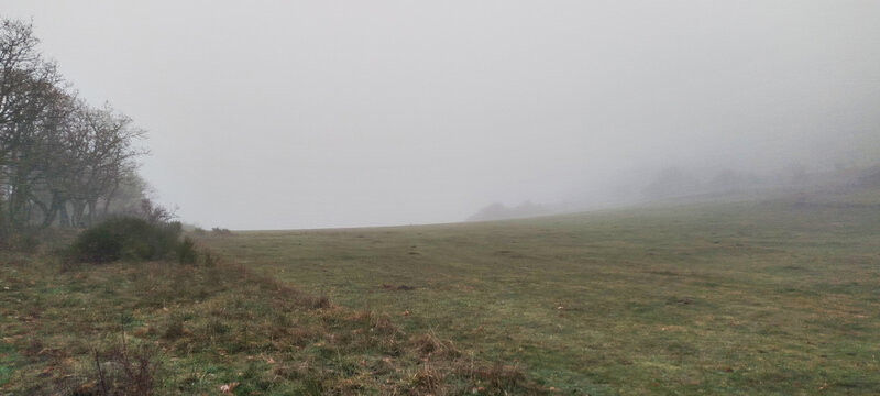 Paisaje de valle monta&ntilde;oso bajo un denso manto de niebla y nubes bajas en un d&iacute;a de invierno en Palencia, Espa&ntilde;a