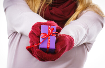 Hands of woman with wrapped gift as surprise for Christmas or other celebration