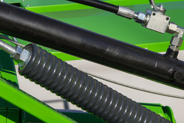 Black pistons or actuators in green pneumatic or hydraulic machine. Technology