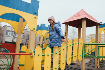 A happy teenage girl runs through a maze on an outdoor playground. Photography, childhood concept.