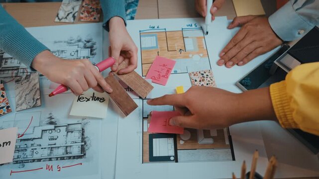 A vibrant scene of a collaborative interior design process, showcasing hands selecting colorful samples and discussing detailed floor plans on a spacious table. SACTR